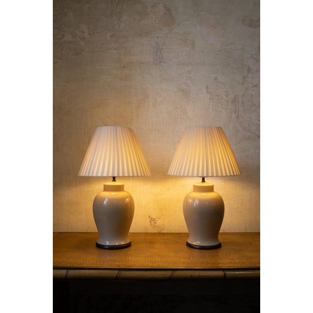 Pair of English-made table lamps from the 1970s. Ivory glazed ceramic bases with a craquelé finish, featuring a rounded...