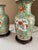 Pair of vintage handprinted porcelain table lamps in green and orange with wooden bases. Includes harp and finial....
