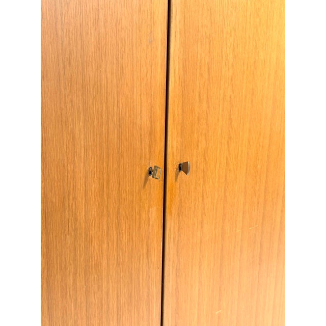 An elegant, two-door vintage wardrobe by swiss-form, likely from the 1960s. A distinctive piece of swiss mid-century...