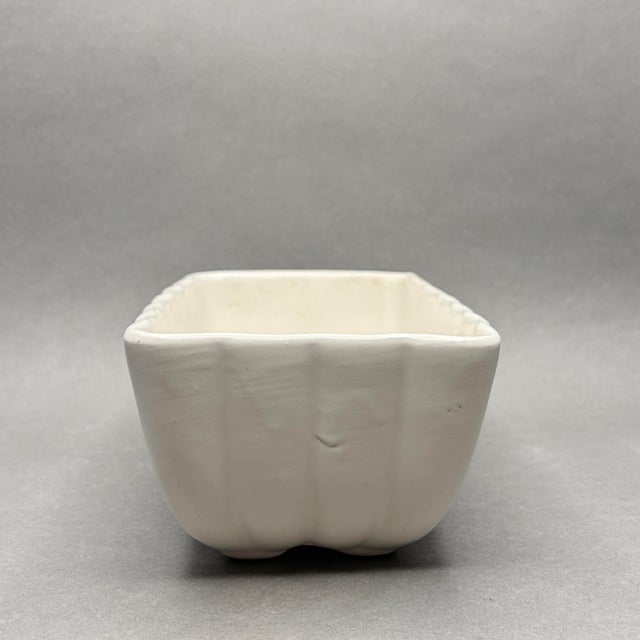 This classic mid-century ceramic planter features a beautifully ribbed, scalloped design in a clean off-white glaze....