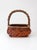 A vintage woven willow basket featuring a low, rounded rectangular body, rich reddish-brown tones, and an organically...