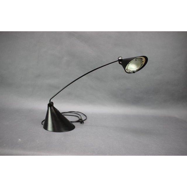 Original italian candy light table lamp dating from the 1990s, distinguished by its sculptural black conical base,...
