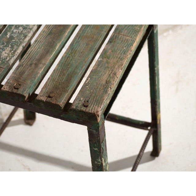 This antique industrial stool in pine wood and iron is an industrial seat with a tubular iron frame and a pine slatted...