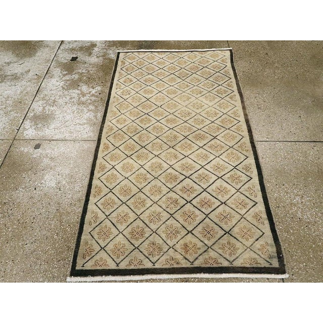 This mid-20th century Turkish Anatolian rug, measuring 3' 1" x 5' 7", presents a refined and orderly composition of...