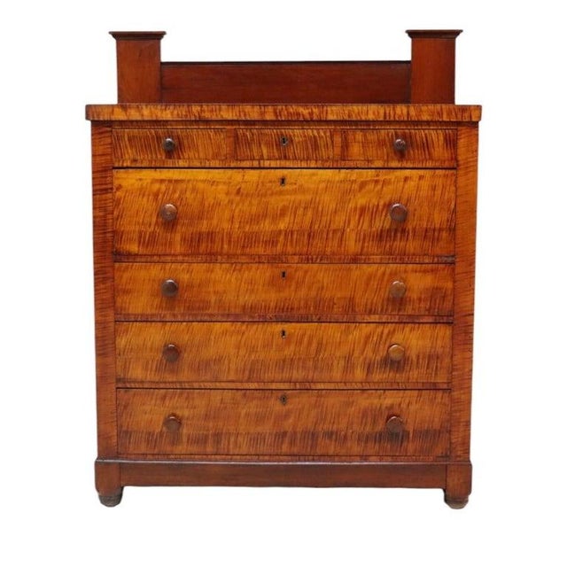 An antique American Empire high chest, crafted circa 1830, featuring a striking combination of cherry and tiger maple...