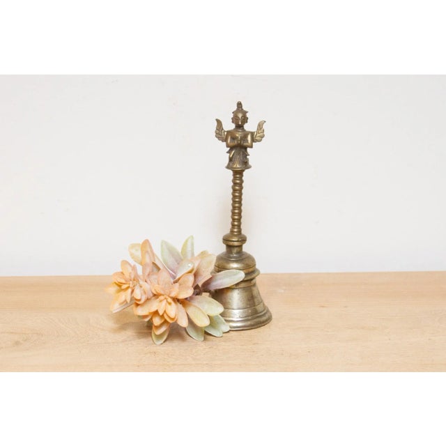 Enchanting 19th-century Indian bronze bell, a testament to exquisite craftsmanship and historical grandeur. This antique...
