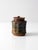 A vintage handmade studio pottery jar with a compact cylindrical form and fitted lid. The surface shows layered blue,...