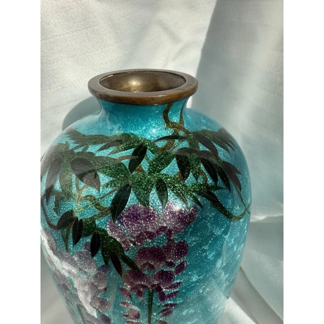 A beautiful antique Japanese cloisonné enamel vase measuring 7 inches tall. The vase features cascading wisteria blossoms...