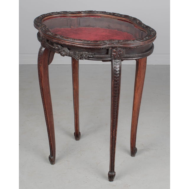 A 19th century French Louis XV style table vitrine or display case made of beech and pine. Oval quatrefoil shaped hinged...