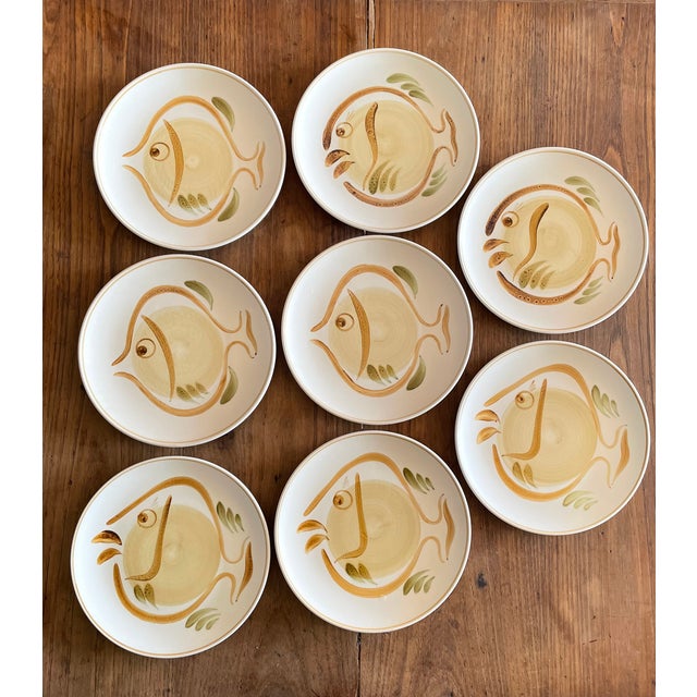 Set of 8 vintage 1970s hand-painted dinner plates. Various stylized fish designs. Abstract naive style. This piece has an...