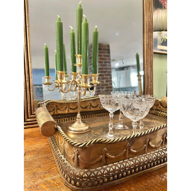 This is a vintage brass candelabra with four scrolling arms surrounding a raised central candleholder. Flared candle cups,...