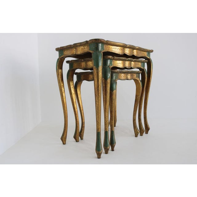 Elegant set of three vintage italian florentine nesting tables in carved and gilded wood with cream and green paint,...