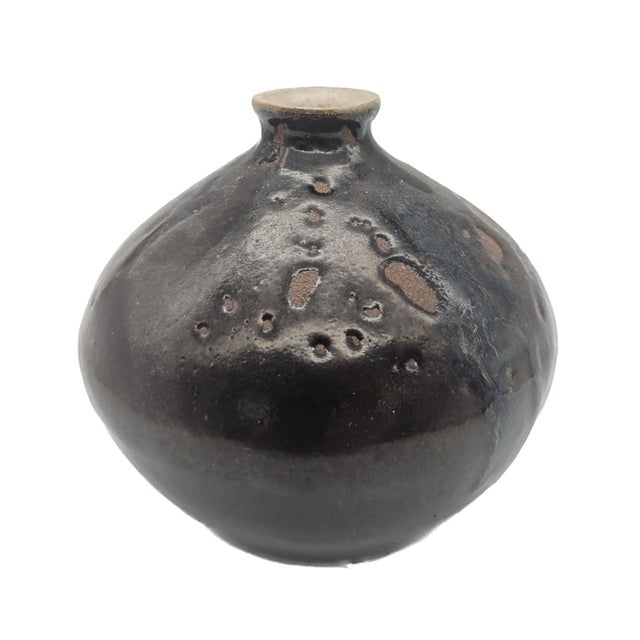 Offered is a high-fired stoneware bud vase that bears the artist's initials and is dated October of 1975, that is glazed...