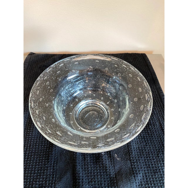 Mouth blown soft clear art glass with a pattern of glass bubbles and seeds around the body. Formed in Roman classical...