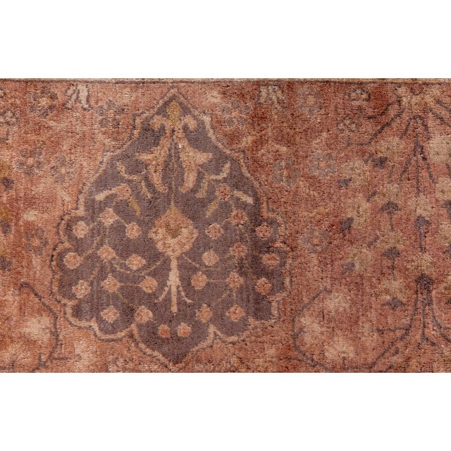 An Indian rug, the chocolate brown field with stylized cusped medallions, flowering vines, and palmettes overall, within a...