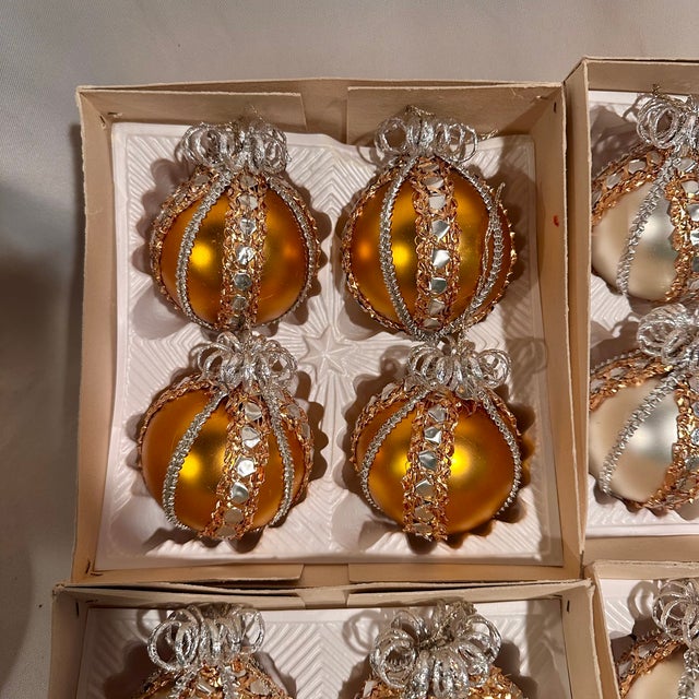 A set of fine European hand blown silver and gold glass ornaments made in West Germany embellished with braided foil trim....