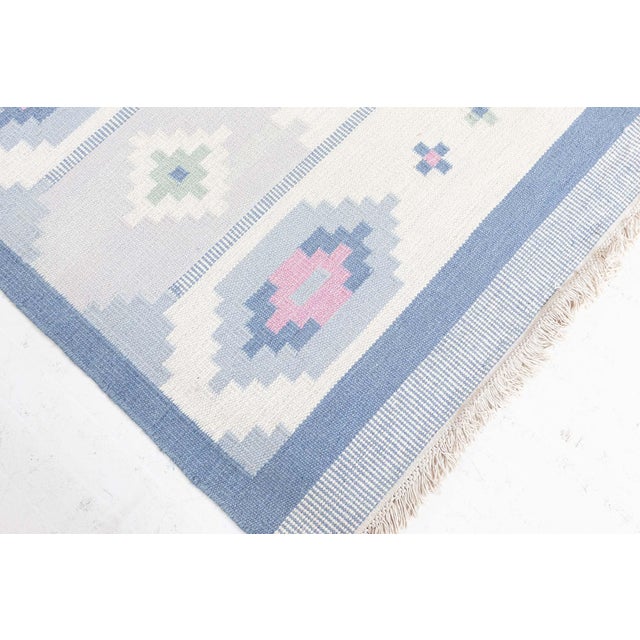 Delicately charming and elegantly structured, this vintage Swedish flat-woven rug captures the soft geometry and pastel...