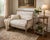 An elegant French-inspired settee featuring a beautifully distressed carved wood frame and classic neutral toile...