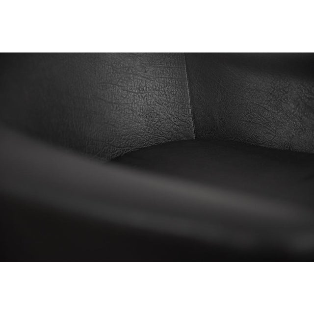 This pair of modernist swivel armchairs was manufactured in Sweden during the 1970s. The armchairs are upholstered in...