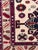 A beautiful hand-knotted Kazak style rug featuring a striking geometric tribal design and a refined ivory field adorned...