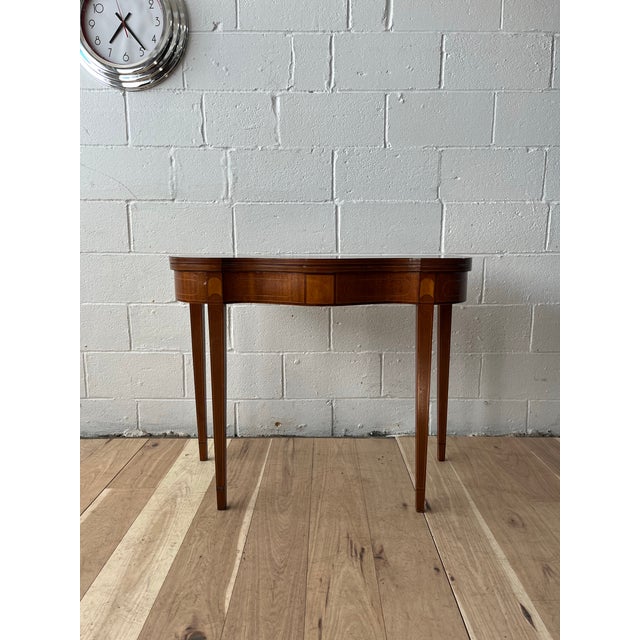 An elegant English Hepplewhite–style console table crafted in richly figured mahogany with refined satinwood inlay. The...