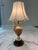 A striking pair of Italian Capodimonte-style table lamps featuring hand-painted porcelain urn bodies decorated with...