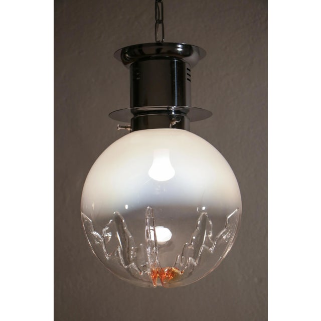 Italian space age ball pendant ceiling lamp in smoked glass with a touch of orange, attributed to mezzega, from the 1970s....