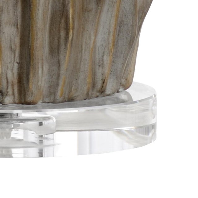 This modern ceramic lamp with a gray/taupe finish, gold detailing and a crystal base was inspired by the texture of the...
