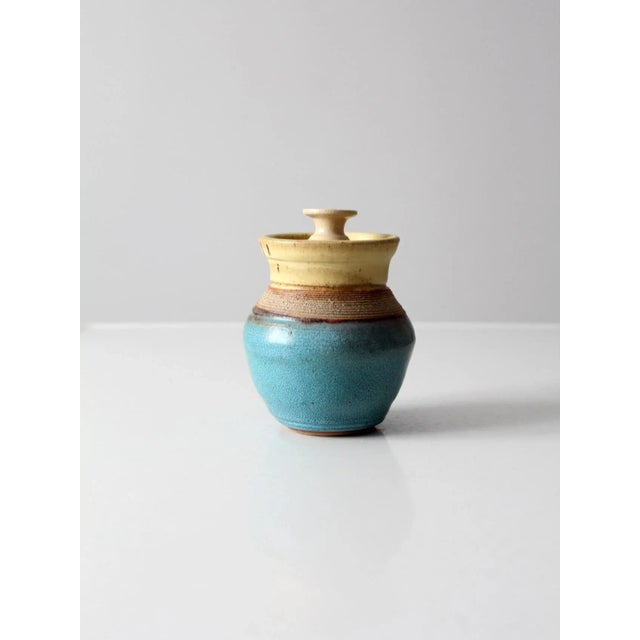 Vintage studio pottery jar featuring a handcrafted form with a beautiful turquoise blue and yellow glaze. Artist signed...