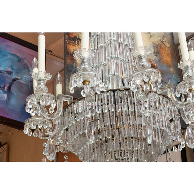 Empire-style design features a tall, tiered frame draped with well dressed crystal prisms that catch and reflect light...