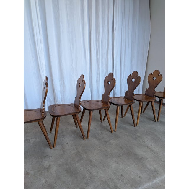 Vintage wooden dining chairs in traditional Tyrolean (Alpine) style. with a shaped backrest and characteristic heart cut-...