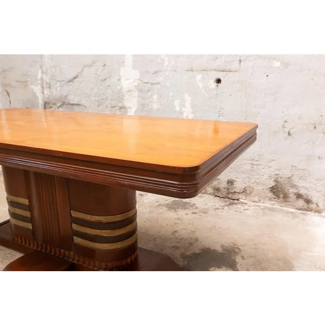Large Art Deco dining table following typical boat furniture designs. Made of teak and brass, it has a worktop with...