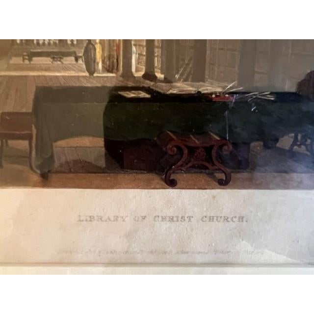This is a framed, hand colored antique aquatint depicting the interior of the Library of Christ Church, Oxford. It...