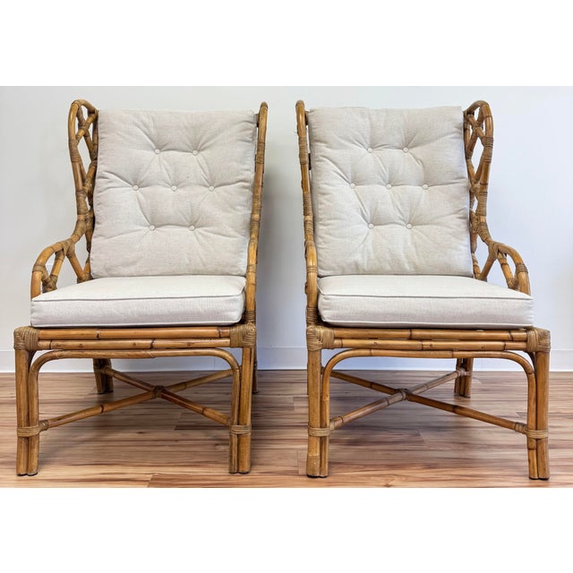 Fretwork rattan wingback chair pair featuring wonderful detail to wings and arms. Stretchers to legs add support. Warm...