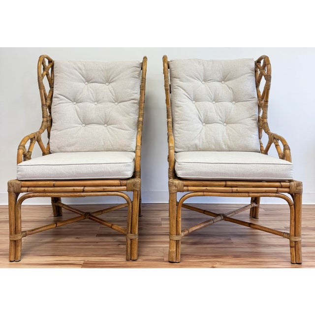 Fretwork rattan wingback chair pair featuring wonderful detail to wings and arms. Stretchers to legs add support. Warm...