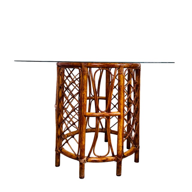 Such a pretty Tortoise finished rattan dining table with a 48" round glass top. Exceptional detail and a perfect old...