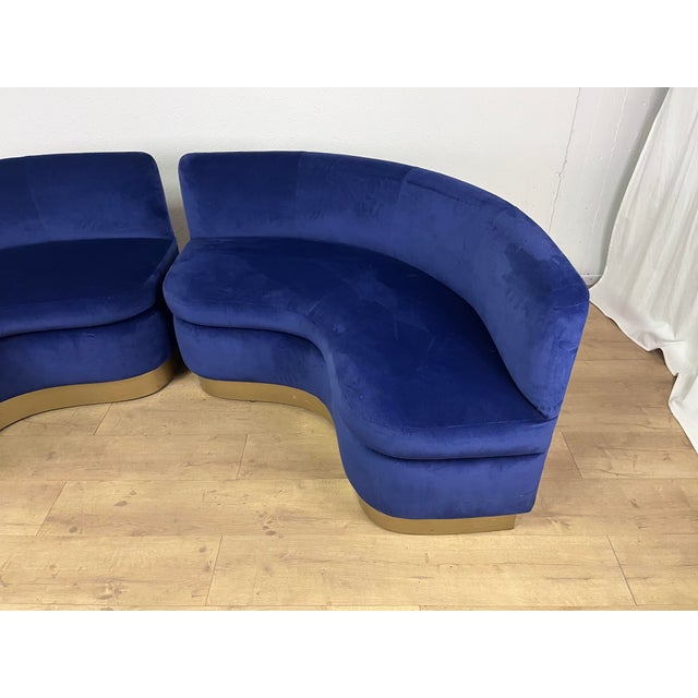 Pair of curved sofas in blue velvet with brass bases, made in Italy in the 20th century. The sofas have been cleaned, with...