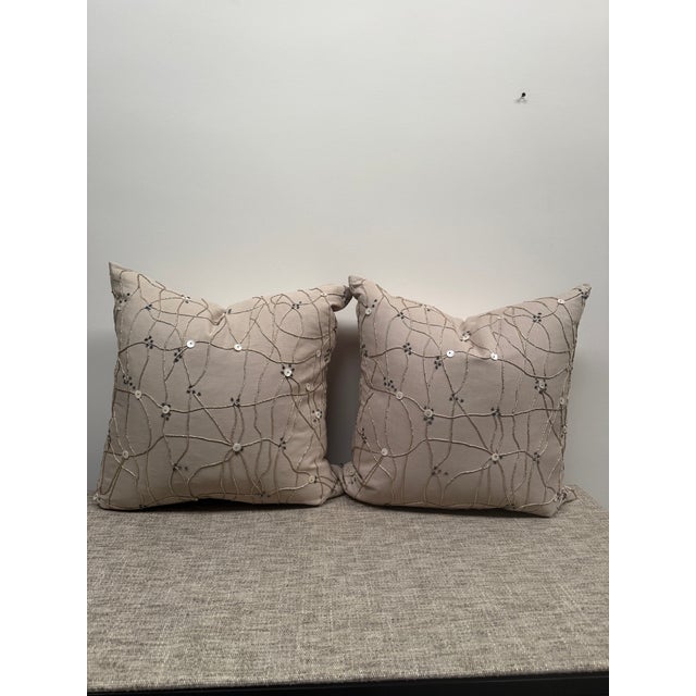 Pair of down filled pillows with button and cord detail on the front