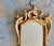 A finely crafted pair of Italian giltwood wall mirrors in the Rococo taste, after Borghese. Each is beautifully carved...