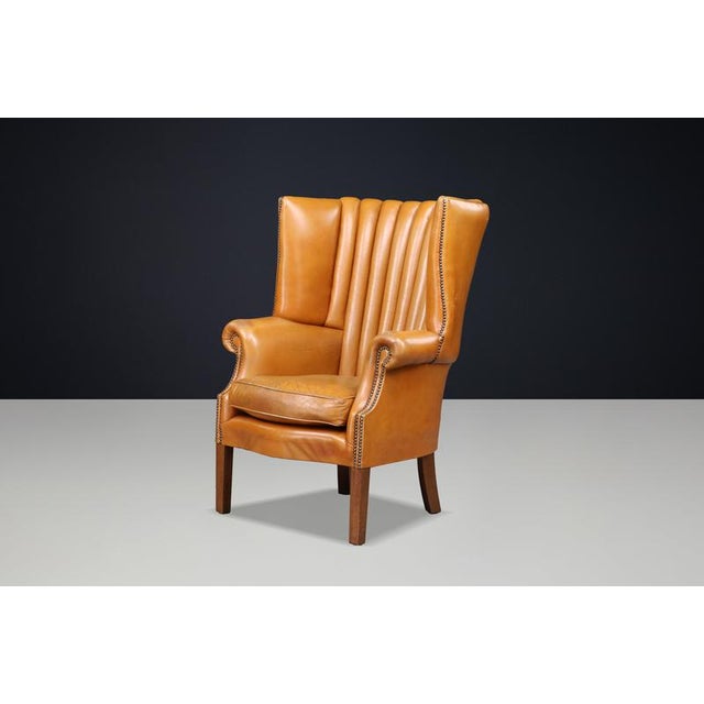 An exceptional and highly sculptural English barrel-back wing chair, dating to circa 1870, distinguished by its commanding...