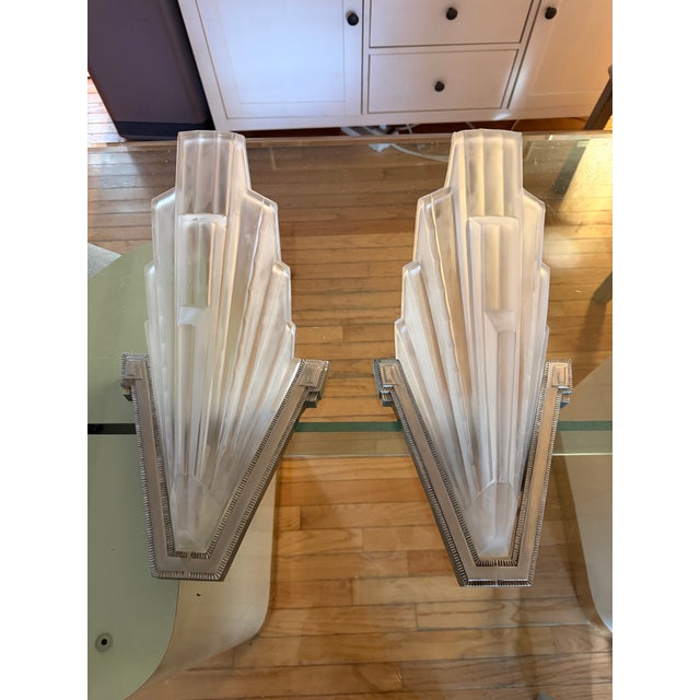 Pair of French Art Deco sconces by the French artist "Marius Ernest SABINO". The shades are clear frosted glass with...