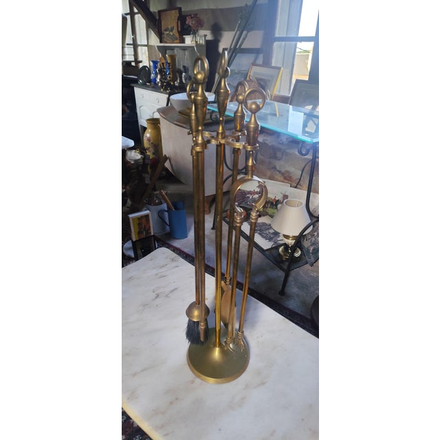 Elegant vintage brass fireplace companion set with matching stand and four fireside tools. A timeless decorative and...