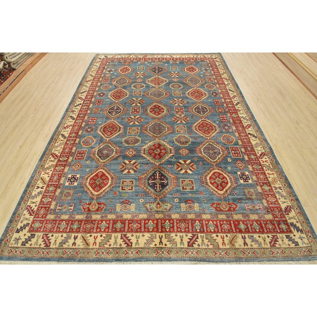 A tribal Caucasian Kazak rug hand-knotted with an all-wool pile on a cotton foundation. This oriental rug features rows of...