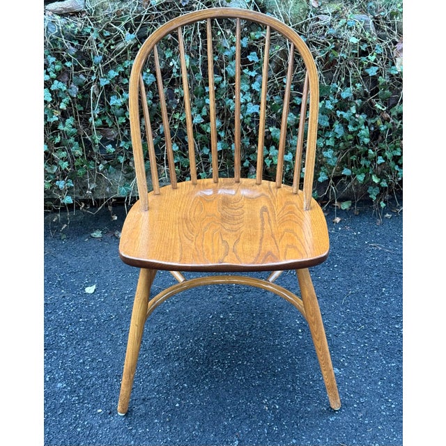 Nice set of solid oak Windsor chairs by Nichols and stone. Features iconic hoop-backed silhouette, spindles that provide a...