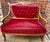 It features rich wine-colored velvet upholstery and ornate etched wood scrollwork with floral detail. It was refinished by...