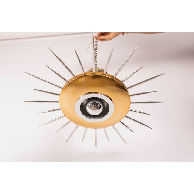 A unique pair of "sunburst" ceiling lamps, made in italy during the 1950s. each lamp features a circular, lacquered metal...