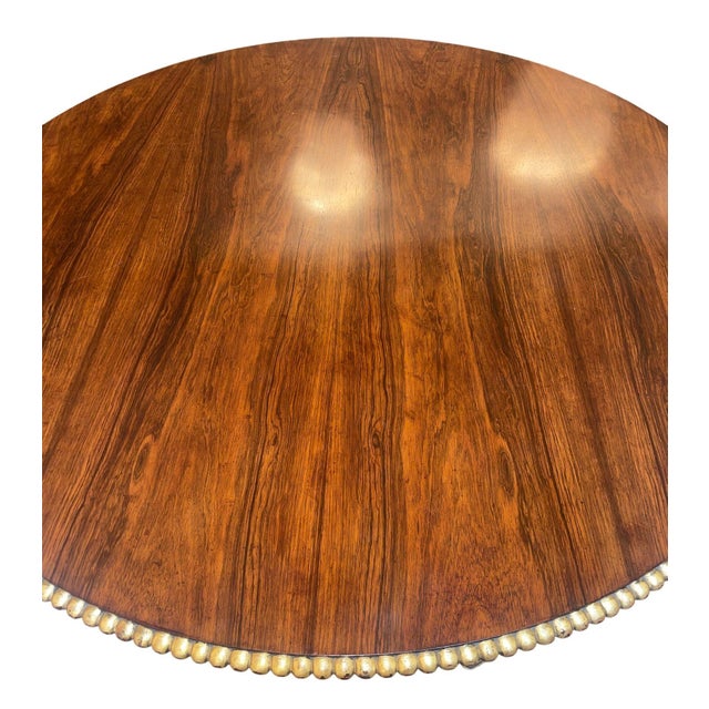 A distinguished late 19th century English pedestal table featuring a richly figured circular wood top accented with...