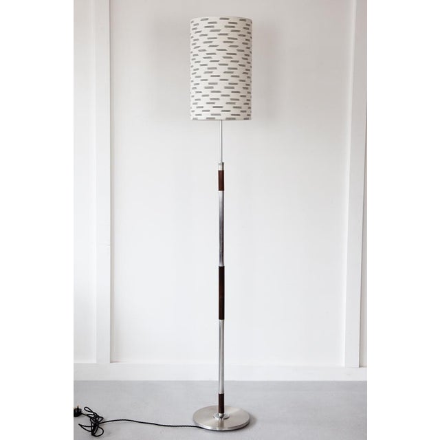 A very elegant Danish floor lamp featuring stainless steel and rosewood bands. The height of the bulb holder can be...