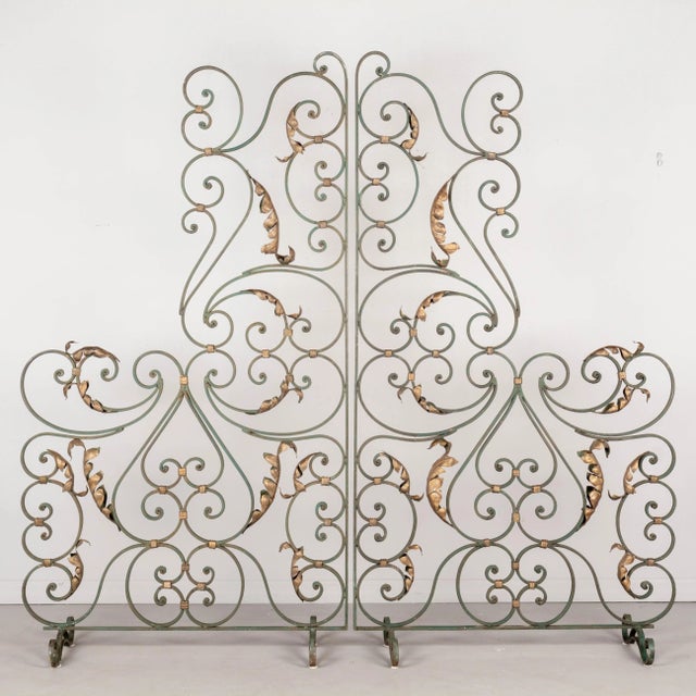 A pair of French Art Deco wrought iron screens or room dividers with original green painted patina and gilt tôle leaves....