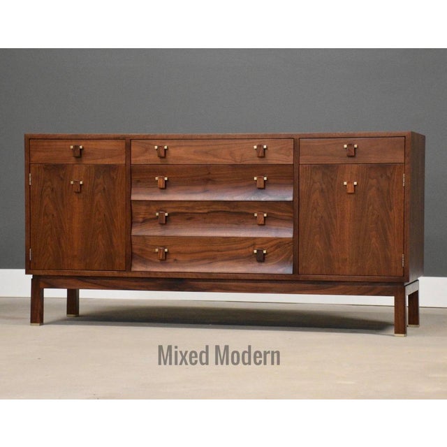 A mid century modern walnut sideboard credenza with two doors and six drawers designed by Edward Wormley for Dunbar....